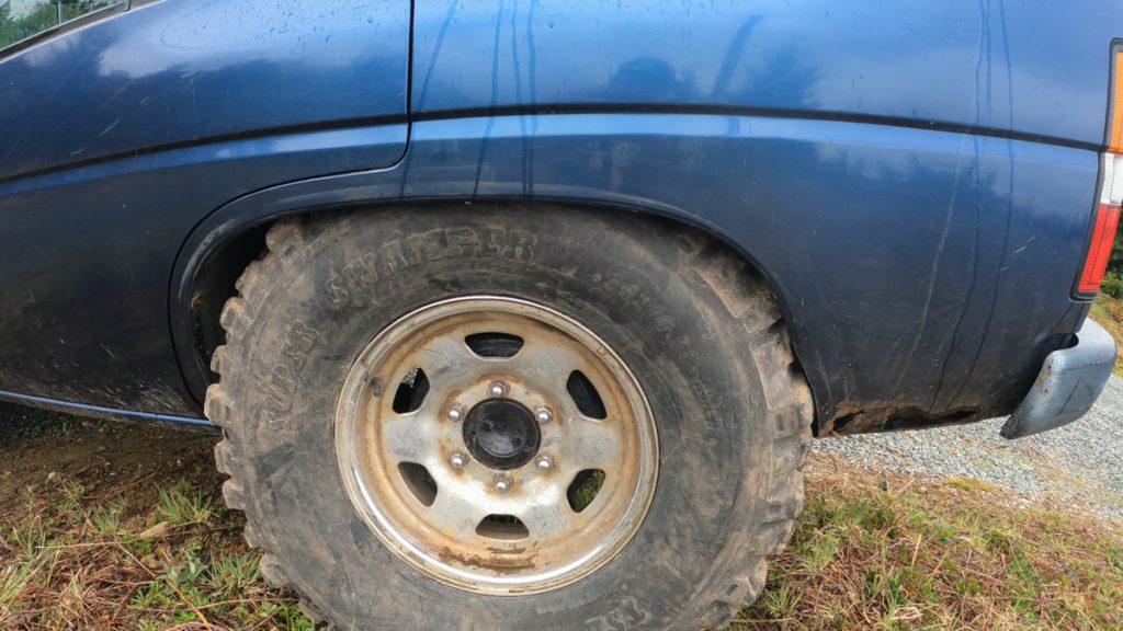 34-inch tire tucked into the trimmed fender of a stock WD21 Nissan Pathfinder